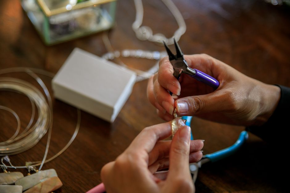 Manos sosteniendo joyería frente a la cámara del teléfono